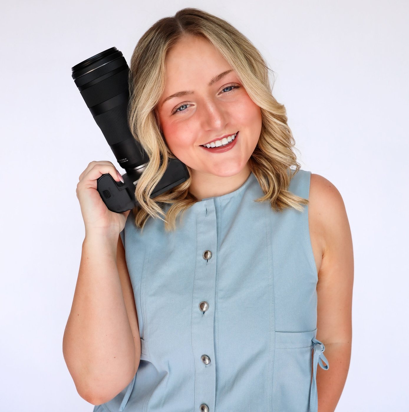 Kaysen smiling with her camera on her shoulder