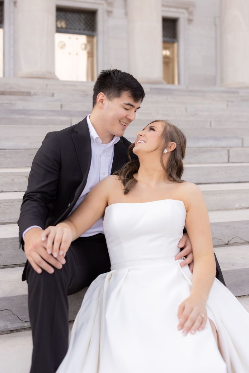 Couple seated on the marble steps of the State Capitol, nose to nose
