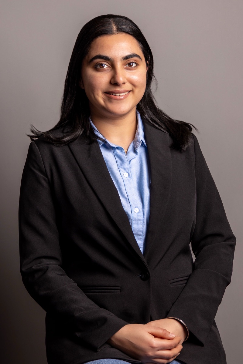 Studio headshot of a woman in a black blazer and light blue shirt