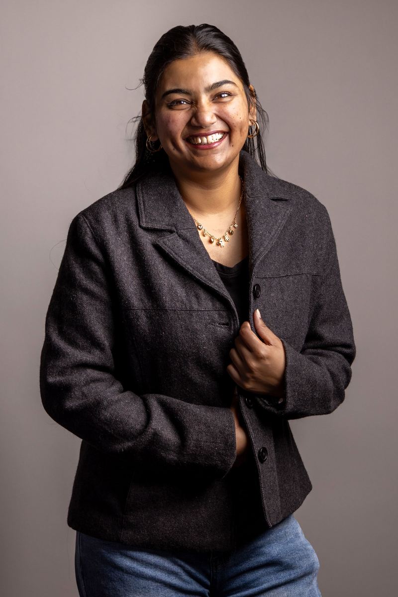 Studio portrait of a woman laughing in a dark blazer