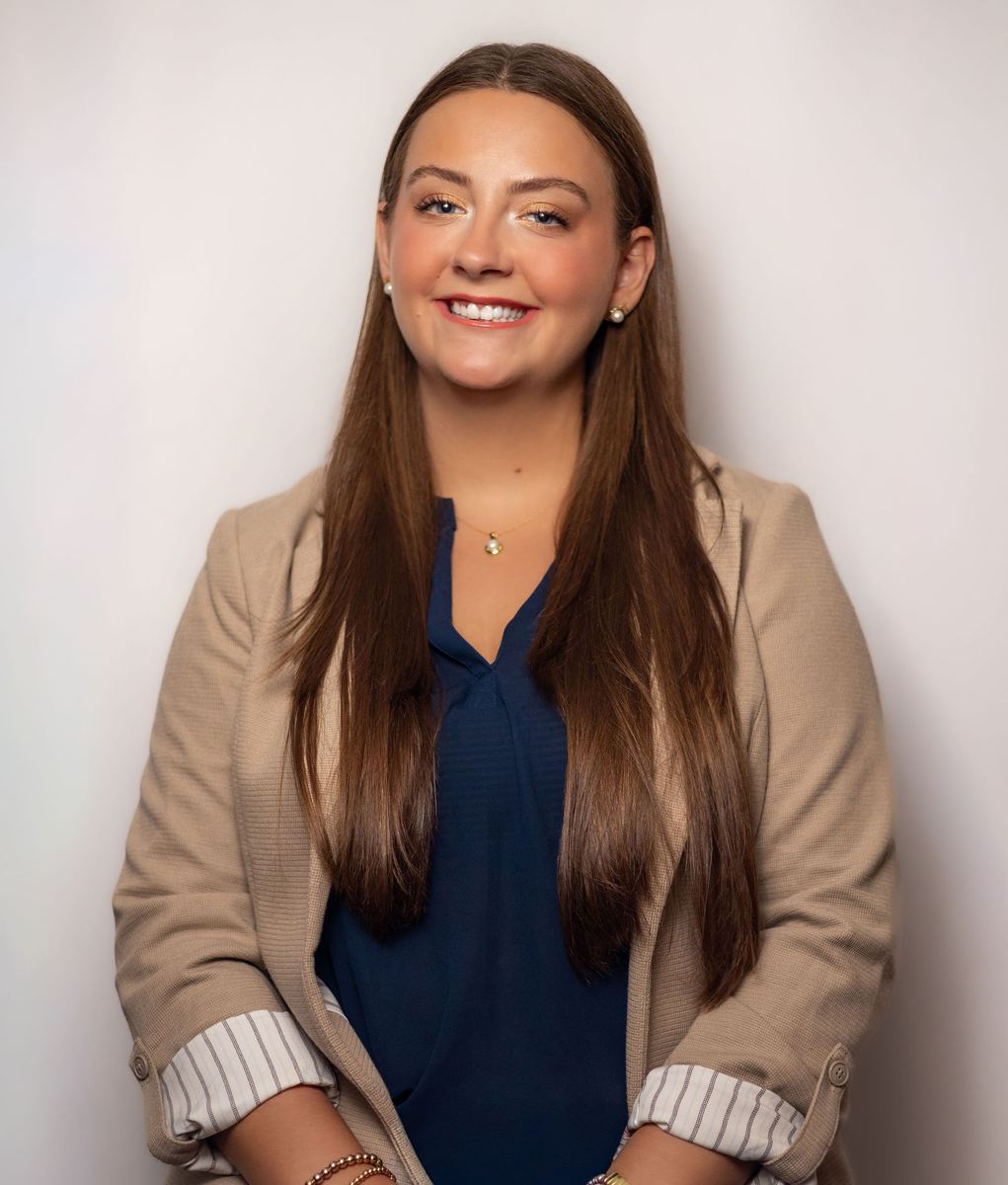 Studio headshot of a woman in a tan blazer