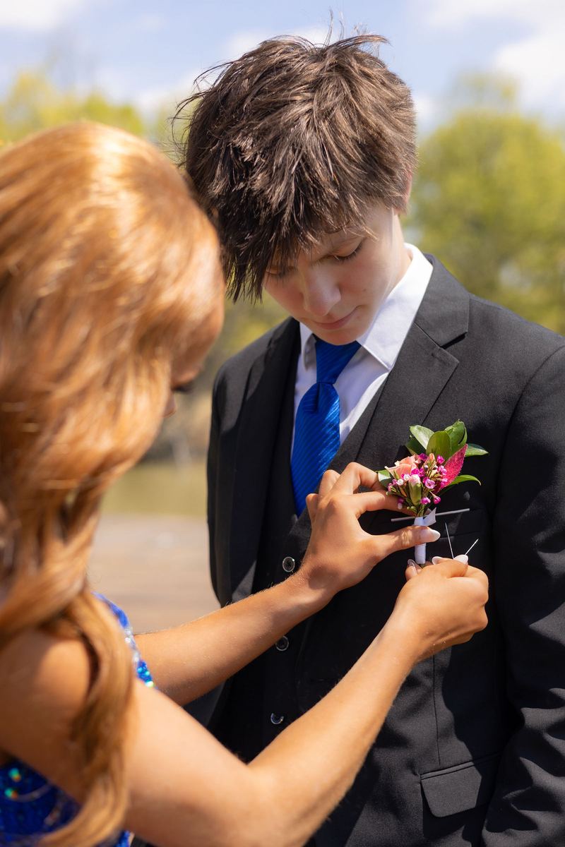 Pinning a boutonniere on a prom date