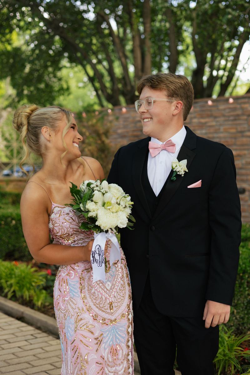 Prom couple laughing at each other in a garden