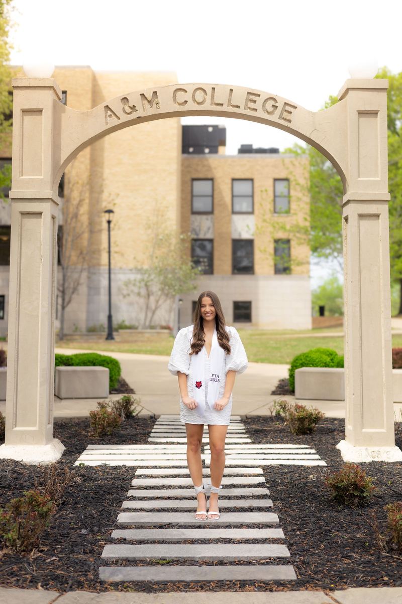 Graduate under the A&M College arch on campus