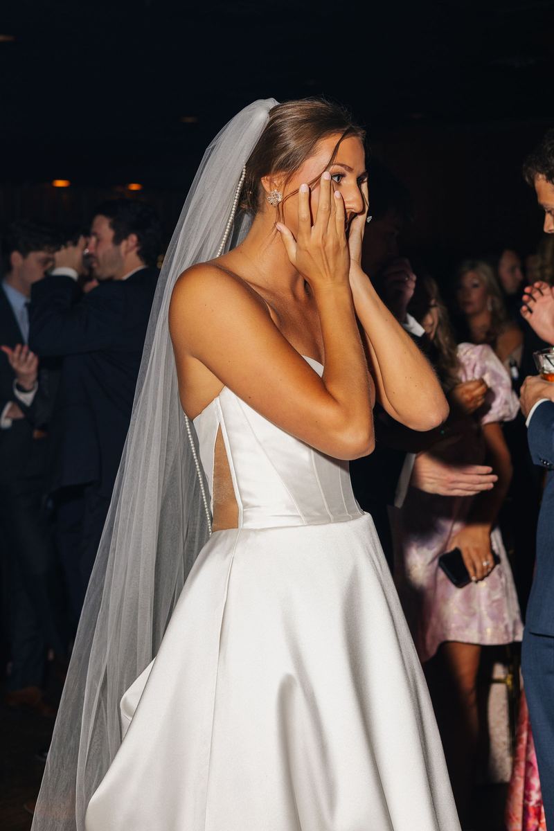 Bride with her hands to her face during the reception