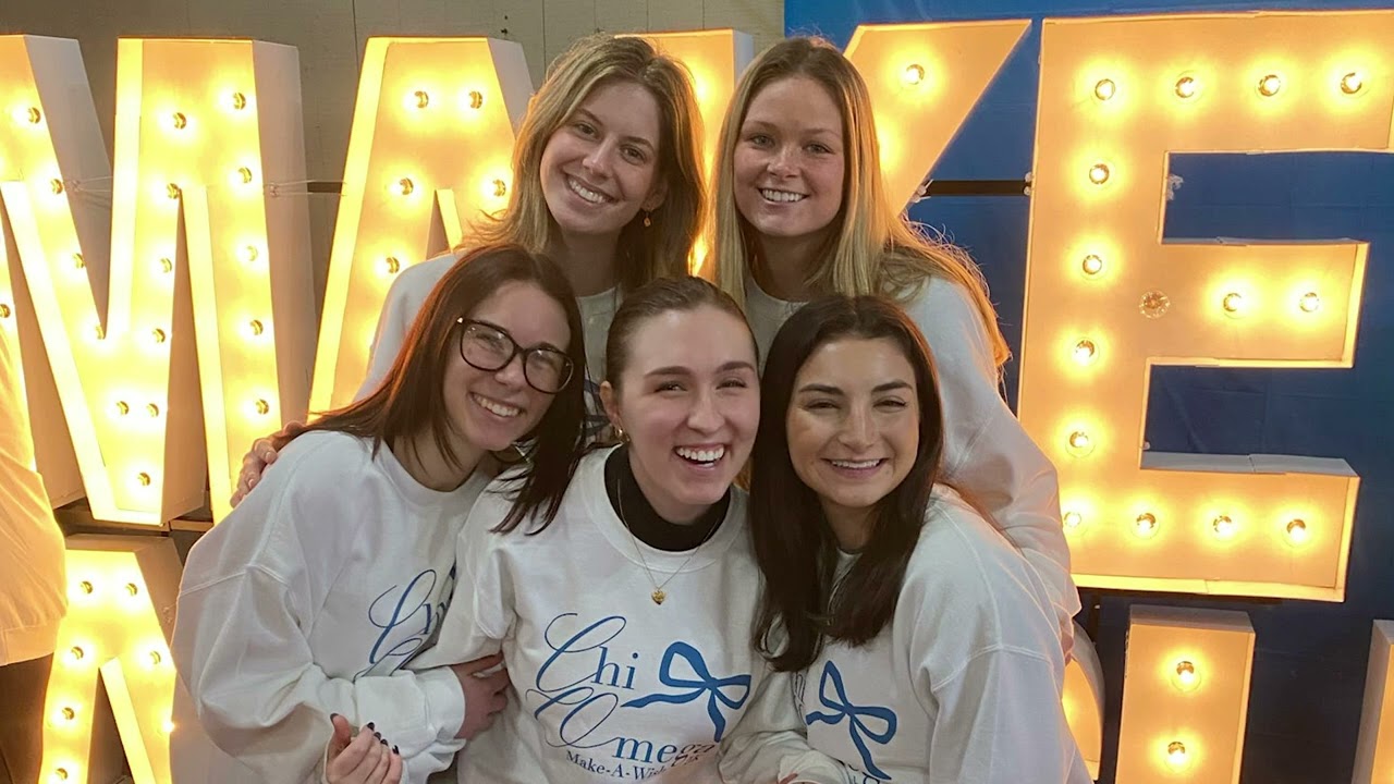 Members in front of lit-up Make-A-Wish letters